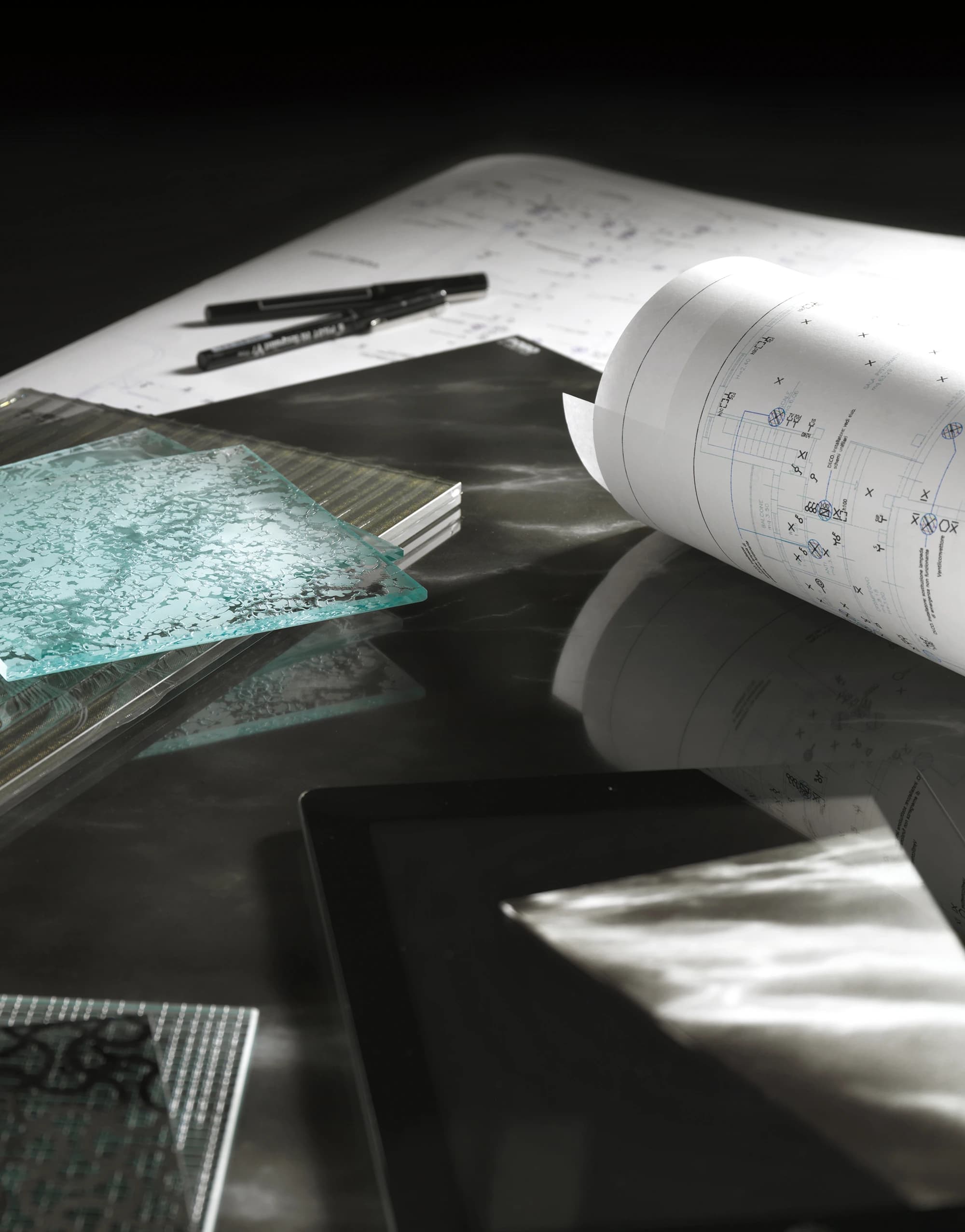 Glass samples, a drawing roll and pencils arranged for a material study