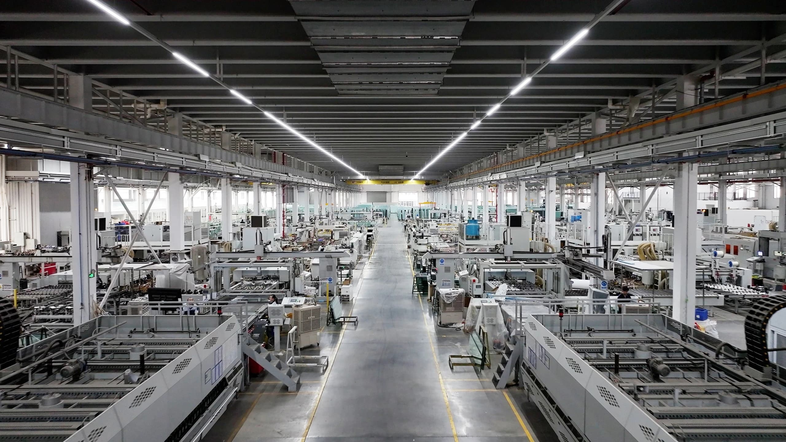 A long central aisle between glass production equipment