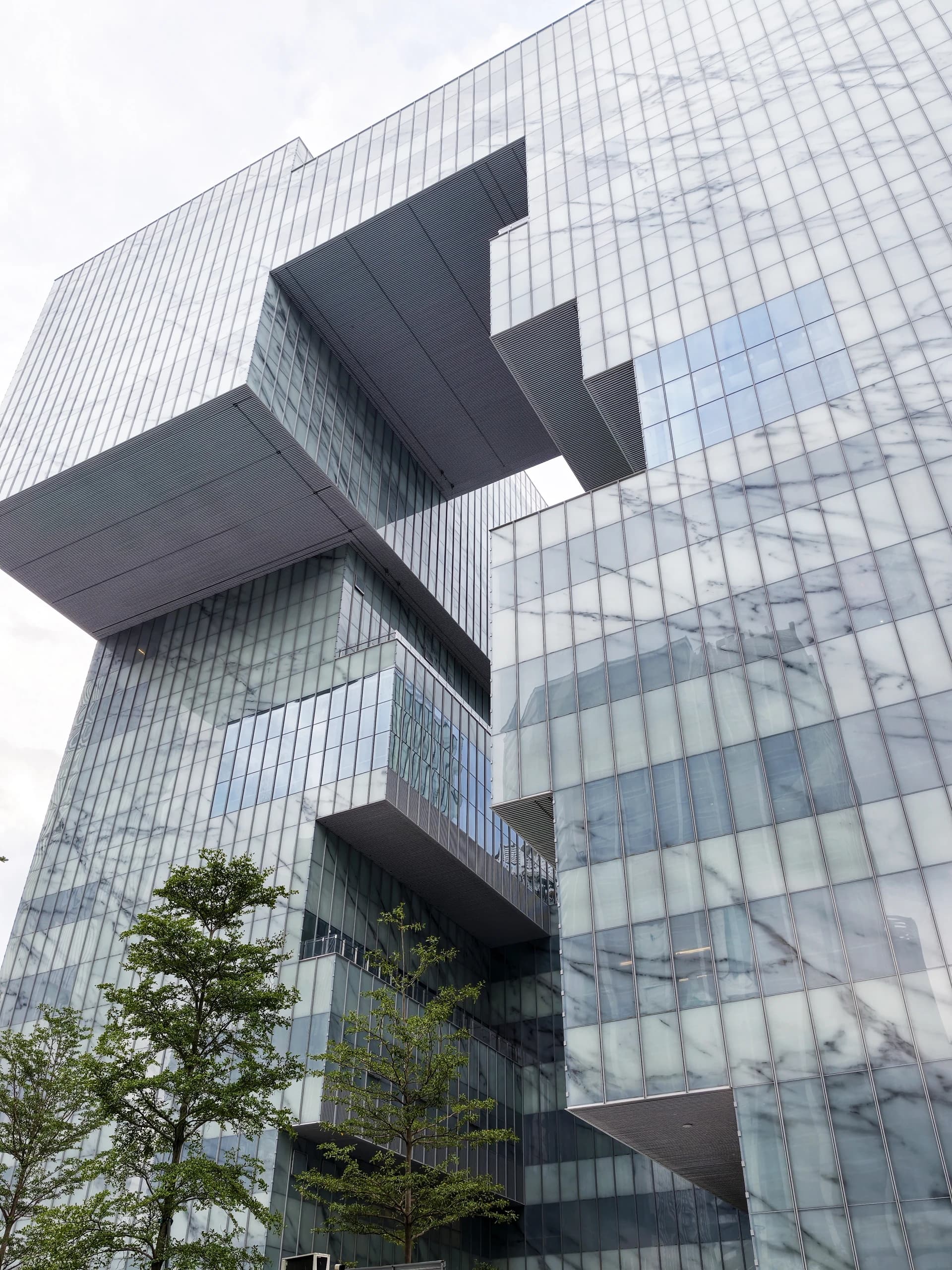 Layered pale glass elevations at Baoan Arts Centre